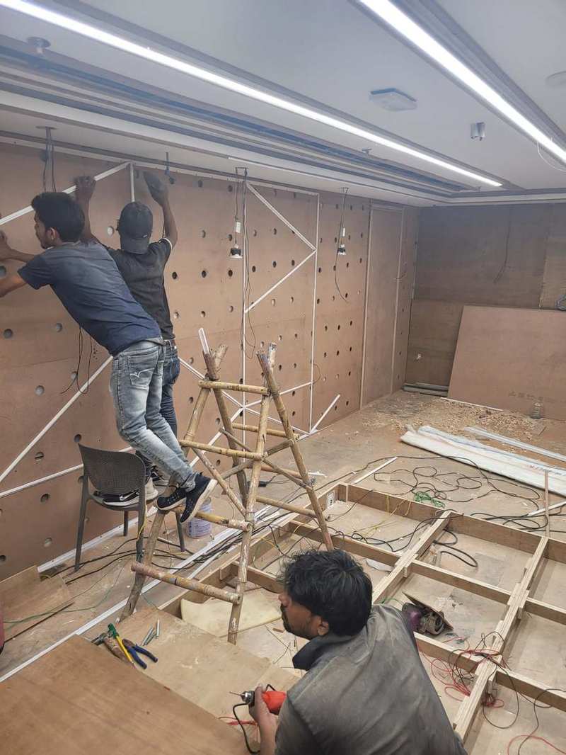 Micro Solutions installation team fixing acoustic wall panels at an auditorium site
